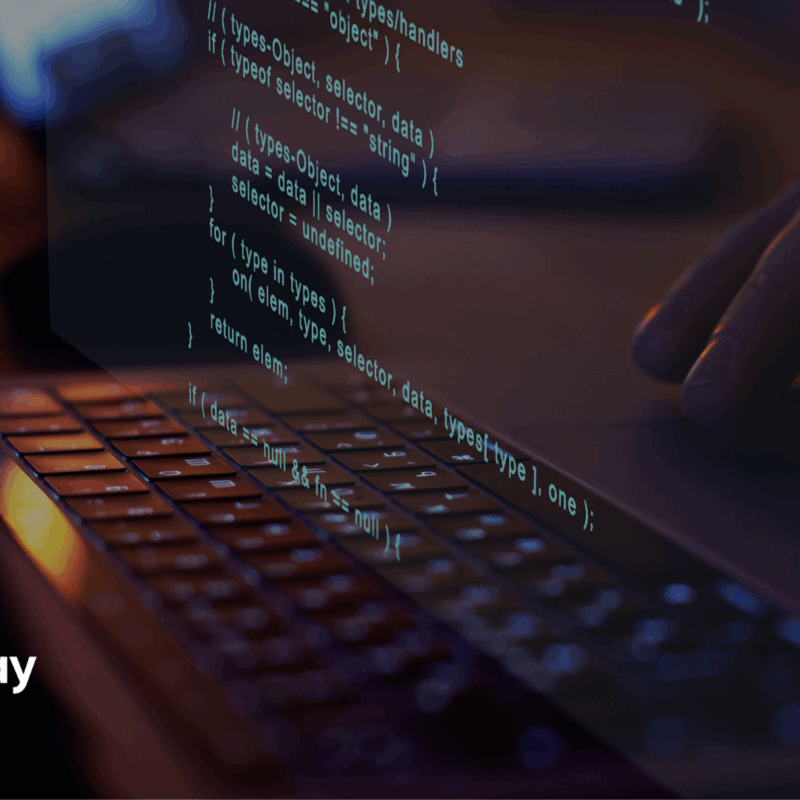 A close-up image of a person typing on a laptop keyboard, with lines of source code digitally overlaid on the screen. The Azupay logo is displayed in the bottom left corner, alongside the title “How We Build Software at Azupay: Fast, Secure and Built to Scale.” The scene is dimly lit, evoking a focused, tech-driven atmosphere.
