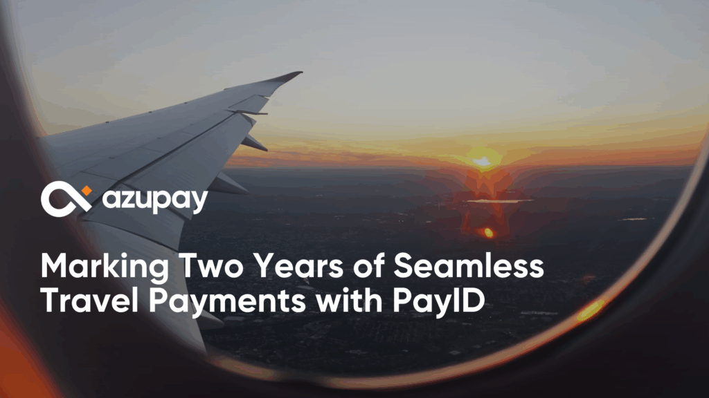 View from an airplane window at sunset showing the wing and landscape below, with Azupay’s logo and the text “Marking Two Years of Seamless Travel Payments with PayID.”